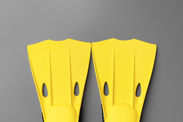 Yellow diving flippers on gray background top view © fotofabrika