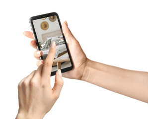 Woman holding modern mobile phone with stylish interior of bedroom on screen against white background