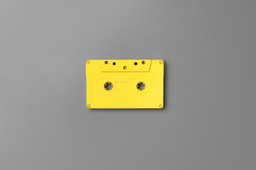 Yellow audio cassettes on gray background top view