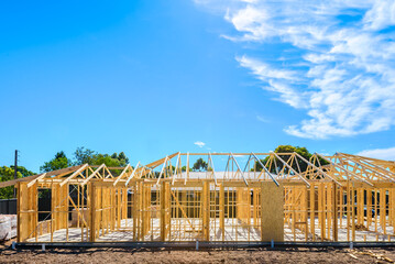New Australian house timber frame installation process at construction site on a bright summer day