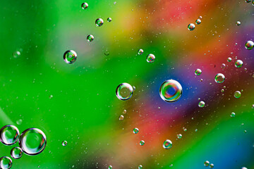 oil drops on water on green background