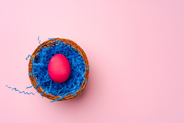 Pink Easter egg in a nest on pink background