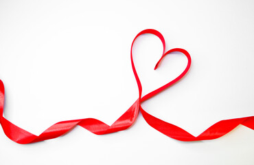 Red heart ribbon on a white background with place for a text. St Valentine's day concept. Expression of love. Romantic. Copyspace