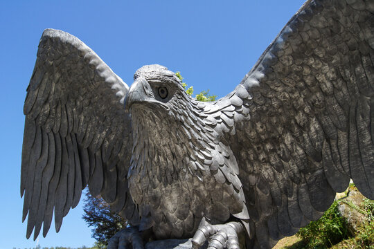 Close-up of a beautiful, imposing metal eagle statue under a clear blue sky.