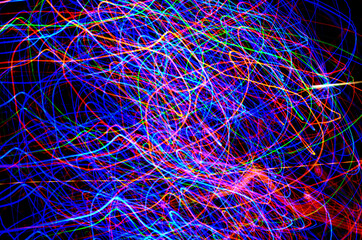 Abstract tangled lines on a black background represent the movements of electrons in their cosmic...