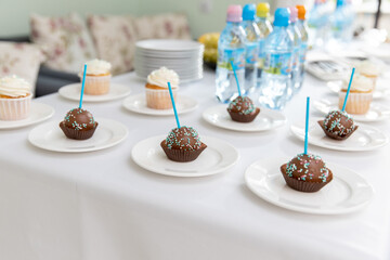 Children's festive table. Cake on a stick for birthday. Sweets for guests