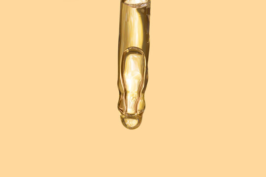 Detail Of Gold Pipette Dropper With Beauty Serum On A Beige Background