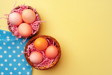 Decorative nest with colorful Easter eggs on yellow background