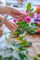 Hands of a person cutting with knife a green and pink flowers