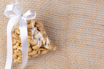 cashew nuts in a gift transparent package on sacking on a white background