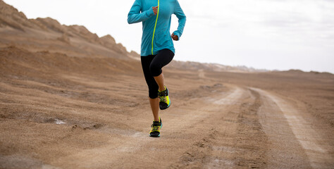 Fitness woman trail runner cross country running  on sand desert