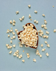 Top view of a heart-shaped wooden bowl with popcorn