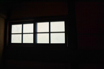 真っ暗な部屋の中から見えるすりガラスの窓