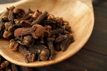 Heap of clove spice on wooden table