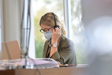 Office worker wearing surgical face mask in open space area