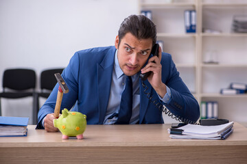Aggressive male employee with hammer in budget planning concept
