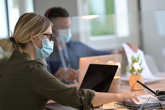 Multiracial staff at work in cowork office - Young people wearing surgical mask for coronavirus
