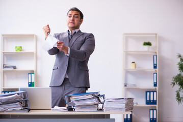 Young employee angry with excessive work holding knife