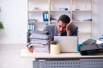 Young male employee unhappy with excessive work