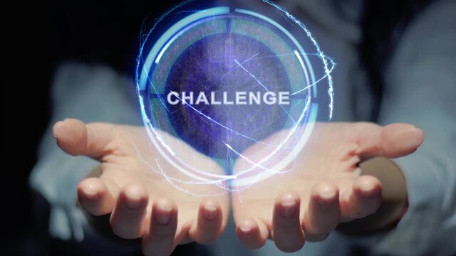 Female hands show a round conceptual hologram with text Challenge. Unrecognizable woman in ashen white on a black background with future holographic technology