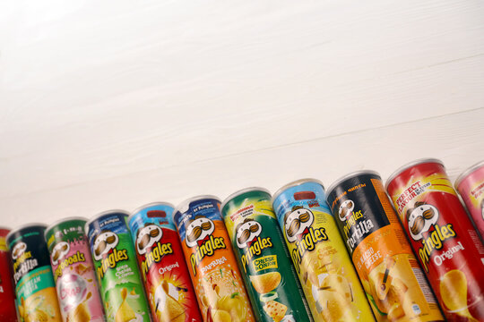 Pringles variety of flavors. Many cardboard tube cans with Pringles potato chips. Pringles is a brand of potato snack chips owned by the Kellogg Company