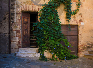 Fototapeta na wymiar A door in an historic stone building in the village of Montemerano near Manciano in Grosseto province, Tuscany, Italy 