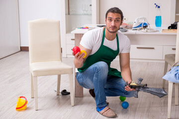 Young male contractor cleaning the flat after kids' party
