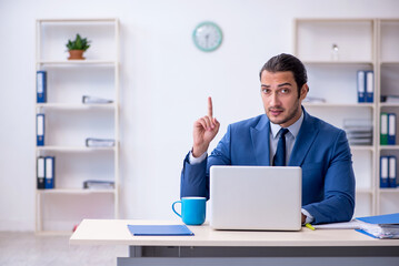 Young male employee working at workplace