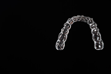 Invisible aligner teeth retainers on a black background