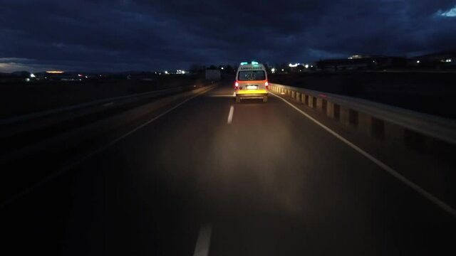 Corrona emergency patient is transported with ambulance van driving fast on road at night