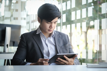 Fototapeta premium Businessman drinking hot coffee and working with laptop while sitting in coffee shop.