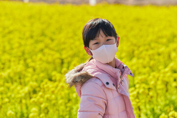 Fototapeta premium 春の満開の菜の花の畑で遊んでいる可愛い子供
