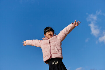 綺麗な青空と元気で遊んでいる可愛い子供