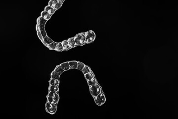 Invisible aligner teeth retainers on a black background