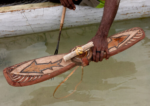 Man on a pirogue making a shark calling, New Ireland Province, Kavieng, Papua New Guinea