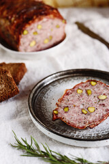 Terrine. Meatloaf. Traditional French cuisine loaf of meat, similar to a pâté, with bacon and pistachios. Selective focus