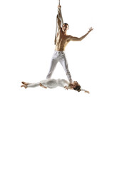 Birds. Couple of acrobats, circus athletes isolated on white studio background. Training perfect balanced in flight, rhythmic gymnastics artists practicing with equipment. Grace in performance.