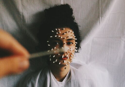 Art fashion portrait of womans face covered with cotton tips 