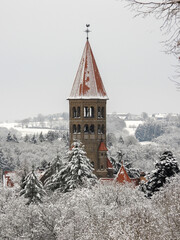 tower of abbey Saint-Maurice of Clervaux, Luxembourg in snowy landscape