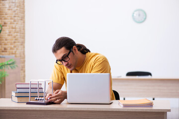 Young male student physics preparing for exams in the classroom