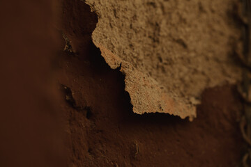 Detail of flaking old rough cast plaster on an ancient building wall with focus to the edge and copyspace