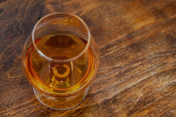 Brandy snifter glass of alcohol drink on wooden table