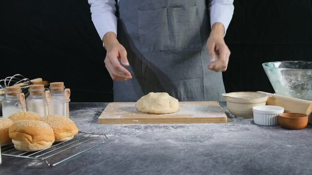 Chef bakery throws loaf of yeast dough onto the bakery table.