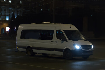 Minibus Moves along the Night Street in the City