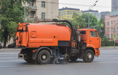 road cleaning vehicle moving along street