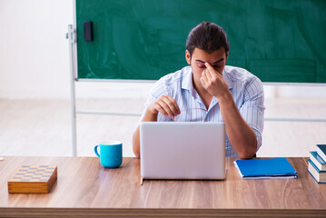 Young male teacher in tele-education concept in the classroom
