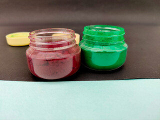 Top view of south Indian tradition Saffron powder and green powder isolated on black background.