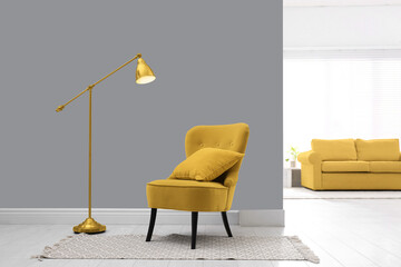 Color of the year 2021. Stylish yellow armchair with cushion, rug and lamp indoors