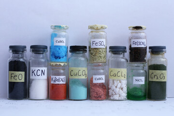 Glass jars with different colored inorganic reagents, with chemical formulas. - obrazy, fototapety, plakaty