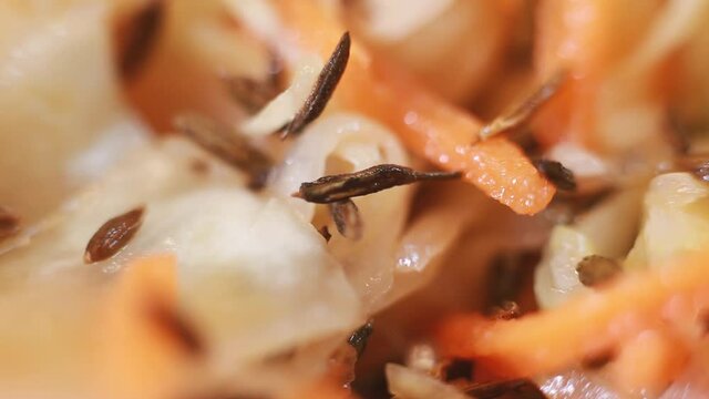 Cabbage and carrot salad sprinkled with cumin. Healthy food. The tray rotates. Selective focus